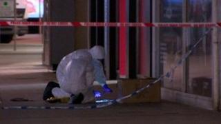 Forensic investigators examined a cardboard box outside the Golf Madness store