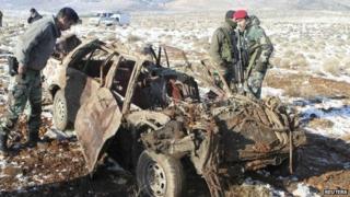 Lebanese soldiers inspect a car damaged by the bombing in the Bekaa Valley in 17 December 2013