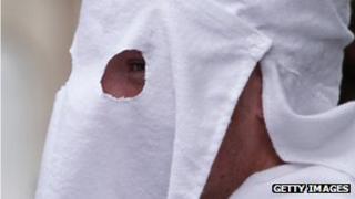 A member of the Klu Klux Klan in a white hood