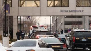 Officers gather in front of the Renown Regional Medical Center after a lone gunman shot and injured four people before killing himself in Reno, Nevada 17 December 2013