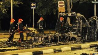 File photo: Firemen douse an ambulance charred in the riot in Little India, Singapore, 9 December 2013