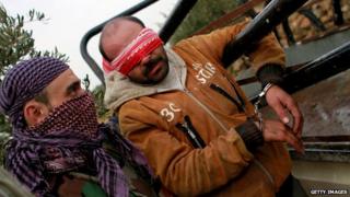 An unidentified man is blindfolded and arrested by Syrian rebels in January 2013