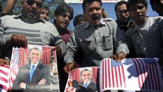 Activists of Sanskriti Bachao Manch, or save culture forum, burn posters of U.S. President Barack Obama and U.S. flags during a demonstration to protest against the alleged mistreatment of New York based Indian diplomat Devyani Khobragade, in Bhopal, India, Wednesday, Dec. 18, 2013.