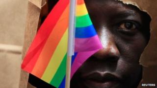 An asylum seeker from Uganda covers his face with a paper bag in order to protect his identity as he marches with the LGBT Asylum Support Task Force during the Gay Pride Parade in Boston, Massachusetts June 8, 2013.