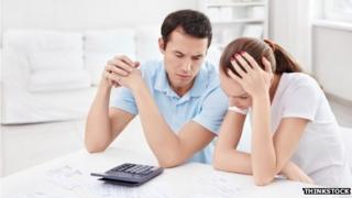 couple looking worried with calculator