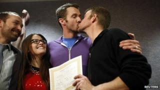 The first gay couple to be married in Utah, Michael Ferguson (2nd R) and his husband Seth Anderson (R), kiss as Blake Ferguson (L) and his girlfriend Danielle Morgan watch after the pair married at the Salt Lake County Clerks office in Salt Lake City, 20 December 2013