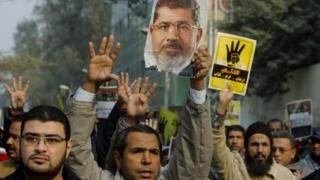 Supporters of former president Mohammed Morsi hold up a poster of him, 20th December
