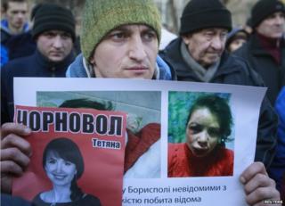 Activists hold photo of journalist and activist Tetyana Chornovol as they rally outside the Ukrainian Interior Ministry in Kiev on 26 December, 2013