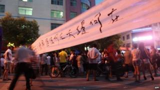 This picture taken on July 17, 2013 shows people walking on street to protest after a fruit seller Deng Zhengjia died in Linwu county, central China"s Hunan province.