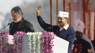 Arvind Kejriwal, right, waves to the crowd at his inauguration as chief minister of Delhi, India, 28 December 2013