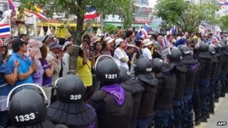 Thai protesters rally along a line of riot police, Bangkok (28 December)