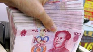 A teller counts Chinese yuan notes