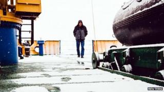 Crew-member of Akademik Shokalskiy walk on snow-covered deck