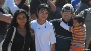 Chilean miner Alex Vega (right, holding a boy) arrives at the San Jose mine for a mass near Copiapo on 17 October, 2010