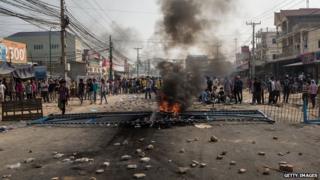 Protesters wait for police behind a barricade on 3 January 2014 in Phnom Penh, Cambodia