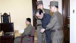 Jang Song Thaek, with his hands tied with a rope, is dragged into the court by uniformed personnel in this December 13, 2013 picture taken from Rodong Sinmun December 12, 2013