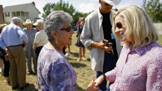 US Senate candidate Liz Cheney, far right, talks to supporters as her opponent Senator Mike Enzi, left, also makes the rounds during a tea party rally in Emblem, Wyoming 24 August 2013