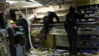 Looters rifle through a store in east London during the August 2001 riots