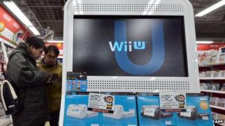 Consumers standing next to Nintendo wii console