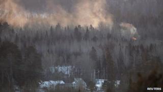 Flames and smoke are seen at the site of a train derailment in Wapske, New Brunswick 8 January 2014