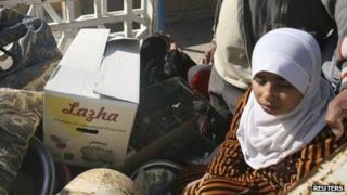 Iraqi Sunni families fleeing the violence with their belongings stop at a checkpoint in the city of Falluja