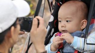 A South Korean parent takes a photo of a baby in Seoul
