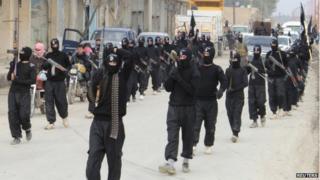 Fighters of al-Qaeda linked Islamic State of Iraq and the Levant carry their weapons during a parade at the Syrian town of Tel Abyad, near the border with Turkey (2 January 2014)