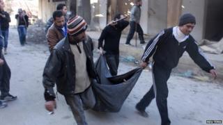 The body of a man believed to have been executed by Islamist State in Iraq and the Levant (ISIS) is carried through Aleppo (8 January 2014)