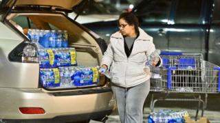 Charleston resident Niru Parikshak loads up the back of her car with bottled water 9 January 2014