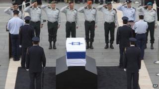 Israeli army generals salute the coffin of former Israeli Prime Minister Ariel Sharon at the Knesset plaza, in Jerusalem, Sunday, Jan. 12, 2014.
