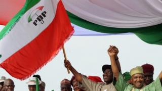Nigerian President Goodluck Jonathan (C) and Vice President Namadi Sambo (R) wave the People's Democratic Party (PDP) flag on the podium at the start of Goodluck Jonathan's presidential campaign at the Lafia Township Stadium in the north central town of Lafia, Nasarawa state on 7 February 2011
