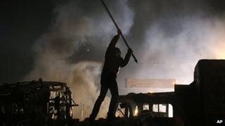 A protester stands on top of a barricade during clashes with police in central Kiev