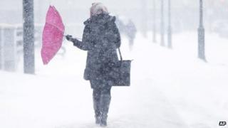 A pedestrian's umbrellas is upset during a winter snowstorm in Philadelphia 21 January 2014
