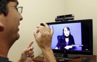A man talking to a remote interpreter via video relay