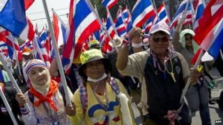 Thai anti-government protesters wave national flags as they parade during a rally in Bangkok on 24 January 2014