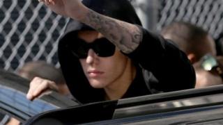 Justin Bieber raises a fist as he exits a Miami jail on January 23, 2014.