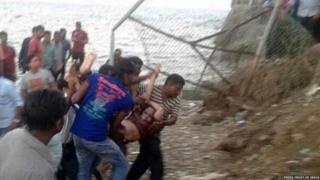 Rescuers carry a victim after a tourist boat capsized in the Bay of Bengal in the Andaman and Nicobar Islands.