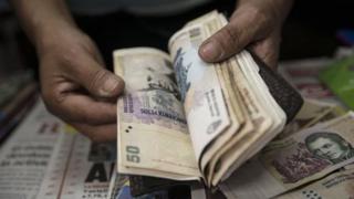 A newsstand owner counts some pesos in Buenos Aires