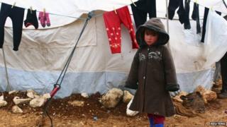 Syrian refugee standing outside a tent