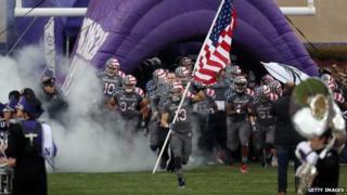 Northwestern University football players take the field in a game on November 16, 2013