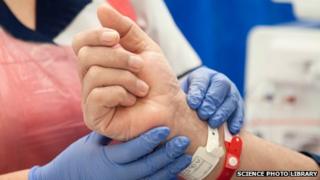 A nurse checks the pulse of a patient