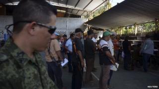 Vigilantes queue up to register their weapons and join a Rural Defence Corps