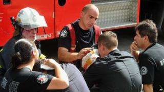 Fire fighters react after their colleagues were killed in a fire in Buenos Aires on 5 February, 2014