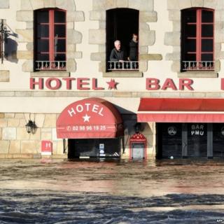 People look out of an upstairs window at flooding in Quimperle, France, 7 February