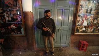 A policeman stands guard at the site of explosions in Peshawar February 2, 2014