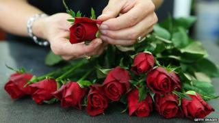 A florist prepares a bunch of roses
