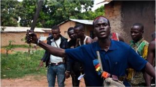 An Anti-Balaka fighter, member of a militia opposed to the Seleka rebel group, lifts up a machete threatening any Seleka that may attack in Bangui on December 14, 2013