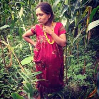 Januka Rasaeli stands in the middle of crops