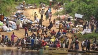 Ivorian fleeing into Liberia across a river - March 2011