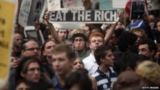 A Occupy Wall Street protestor holds up a sign reading "eat the rich" in September 2011.